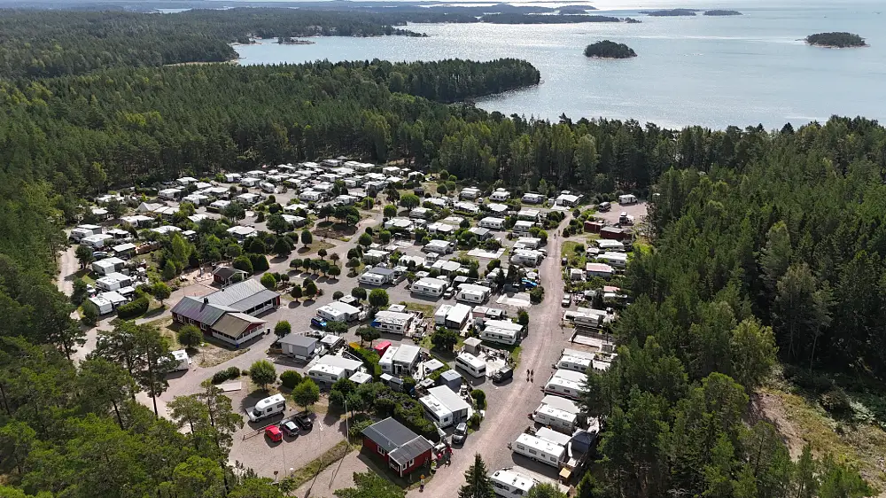 Vy över Dragsviks husvagnsklubb med husvagnar och havet i bakgrunden